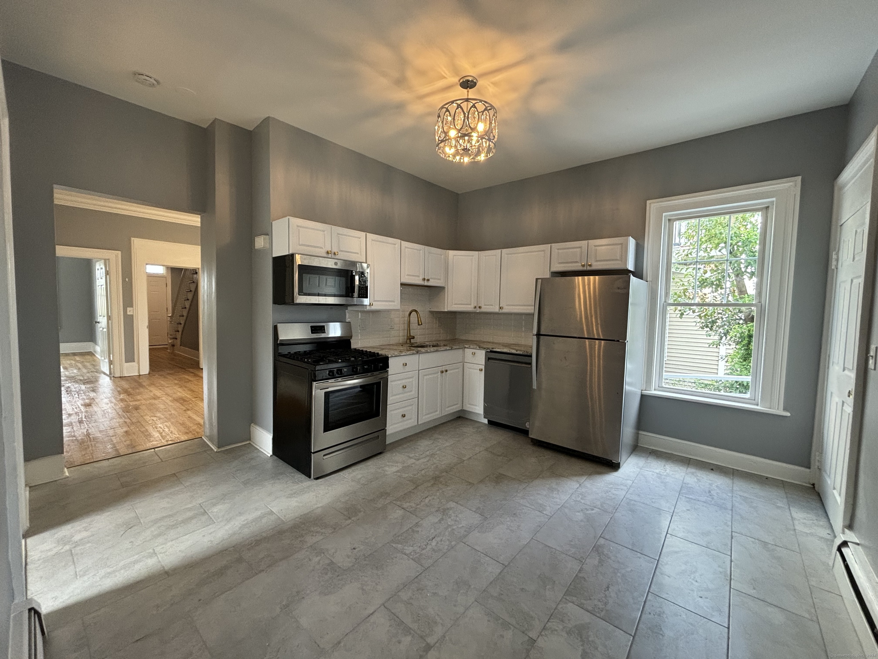 a kitchen with stainless steel appliances granite countertop a refrigerator and a stove top oven