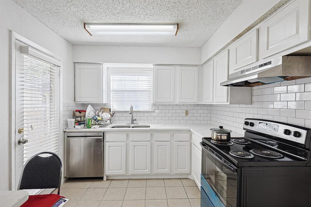 a kitchen with cabinets appliances a sink and a window