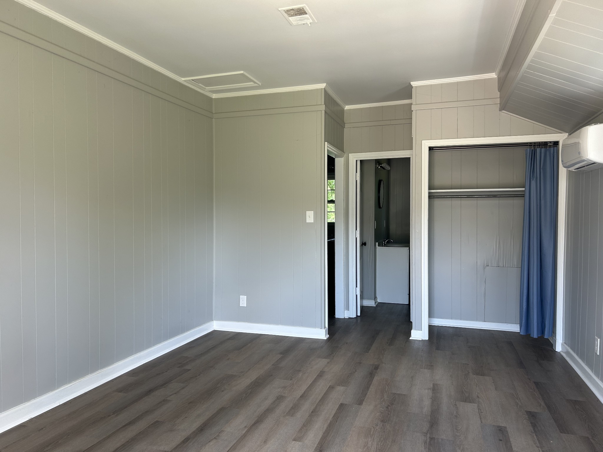 a view of an empty room with wooden floor