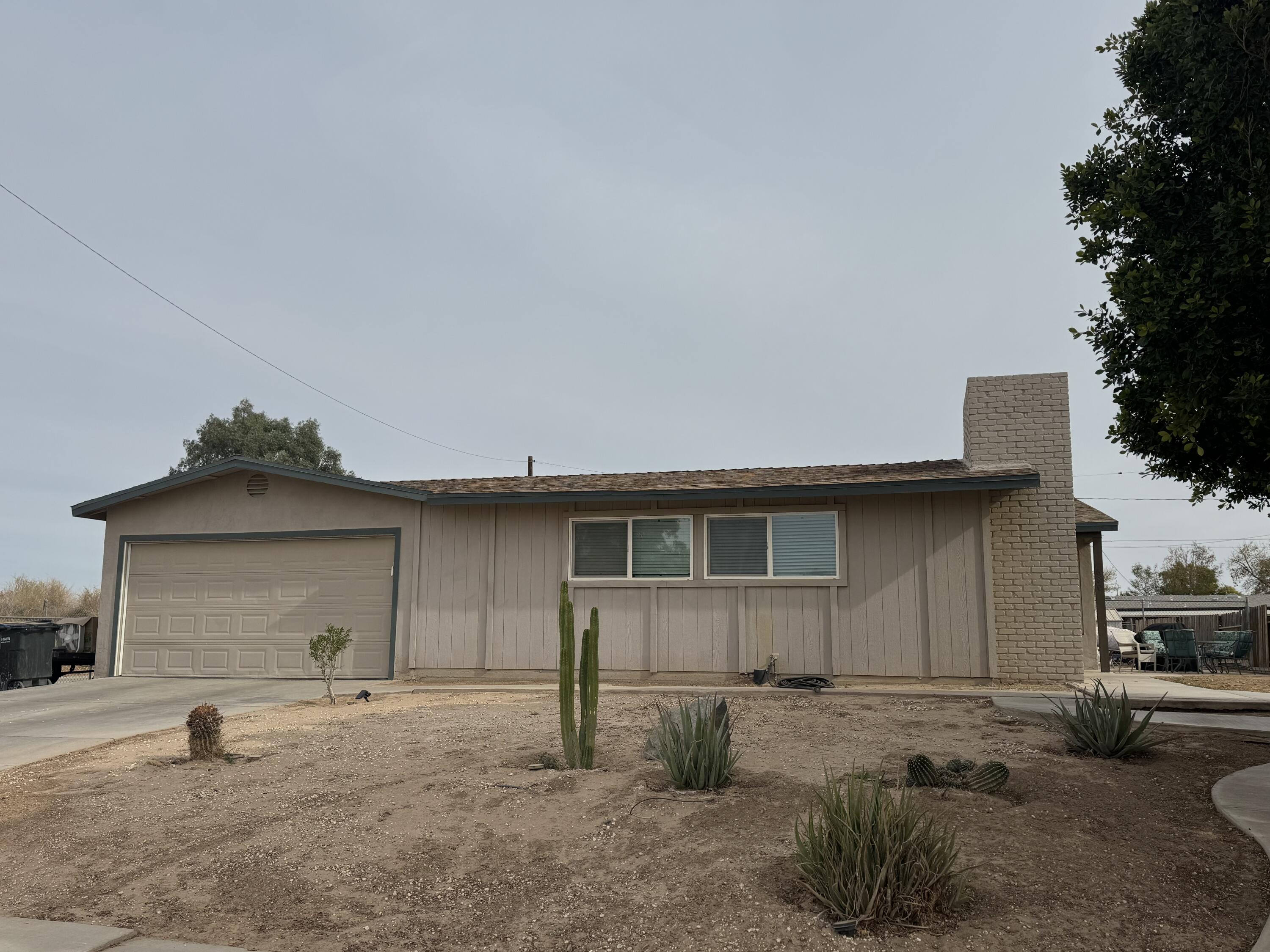 a view of a house with backyard and trees