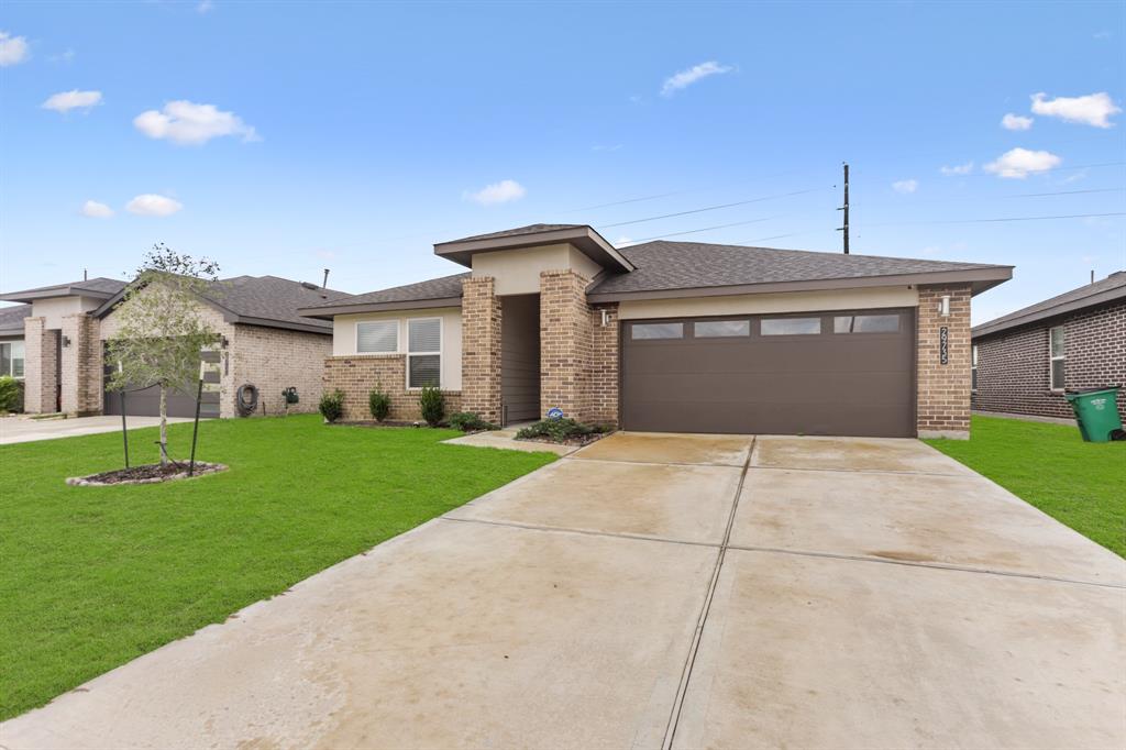 a front view of a house with a yard and garage