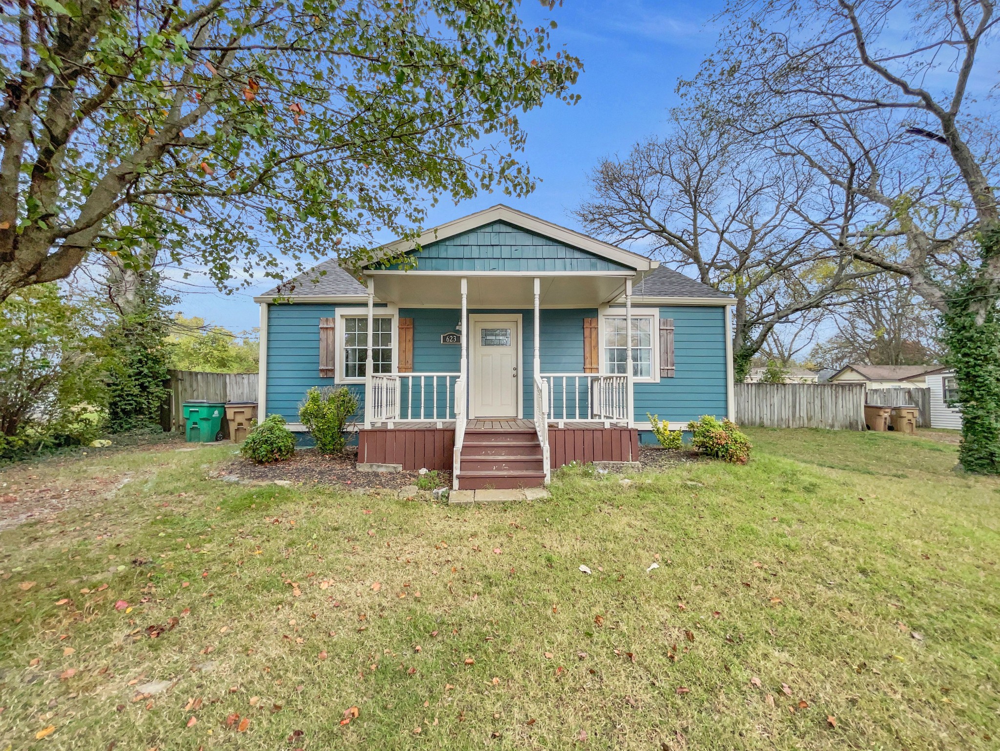 a view of a house with a yard and large tree