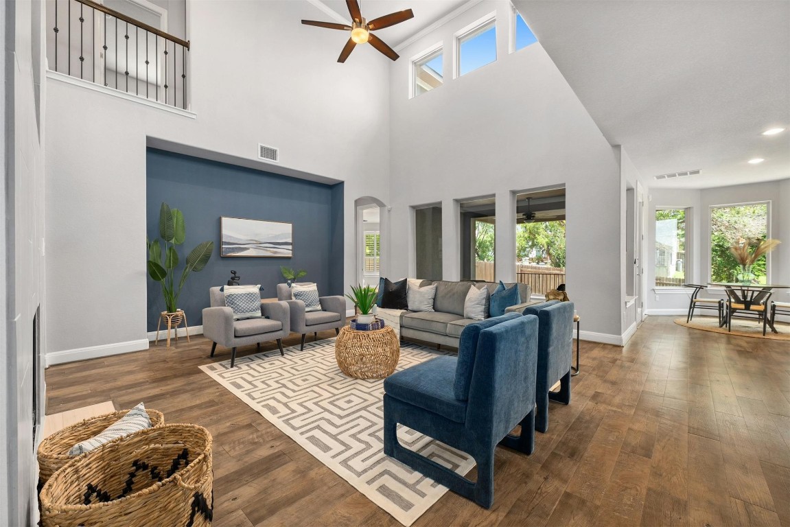 The large windows in the living room allow natural light to flood the space, highlighting the beautiful wood floors