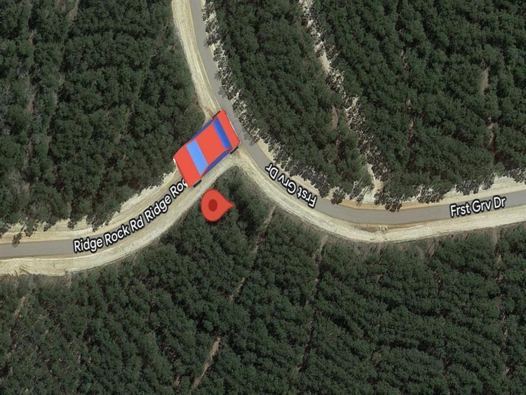 This aerial image shows a forested, corner lot at the intersection of Ridge Rock Rd and First Grv Dr, potentially offering privacy and natural surroundings for a new home.