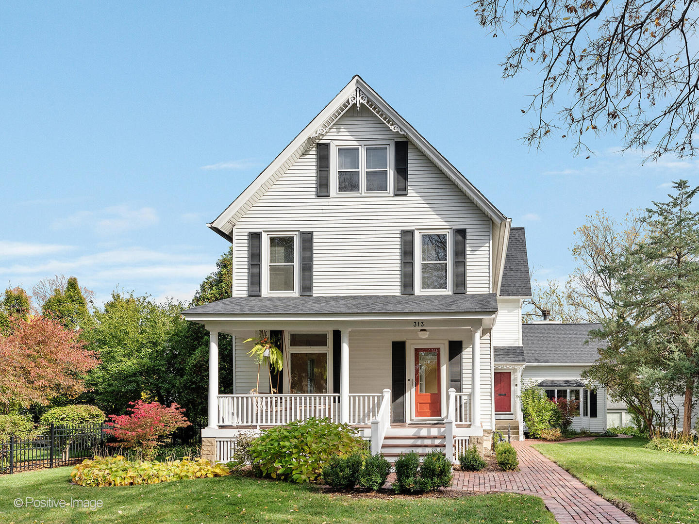 a view of a white house with a big yard and potted plants