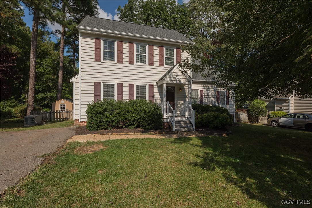 a front view of a house with a yard and trees