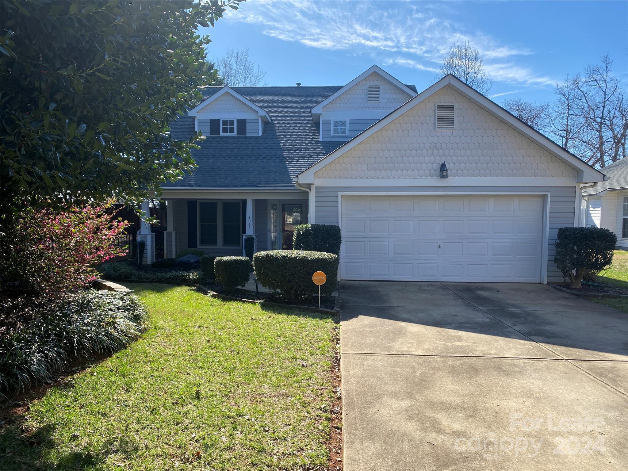 a front view of house with yard and trees in the background