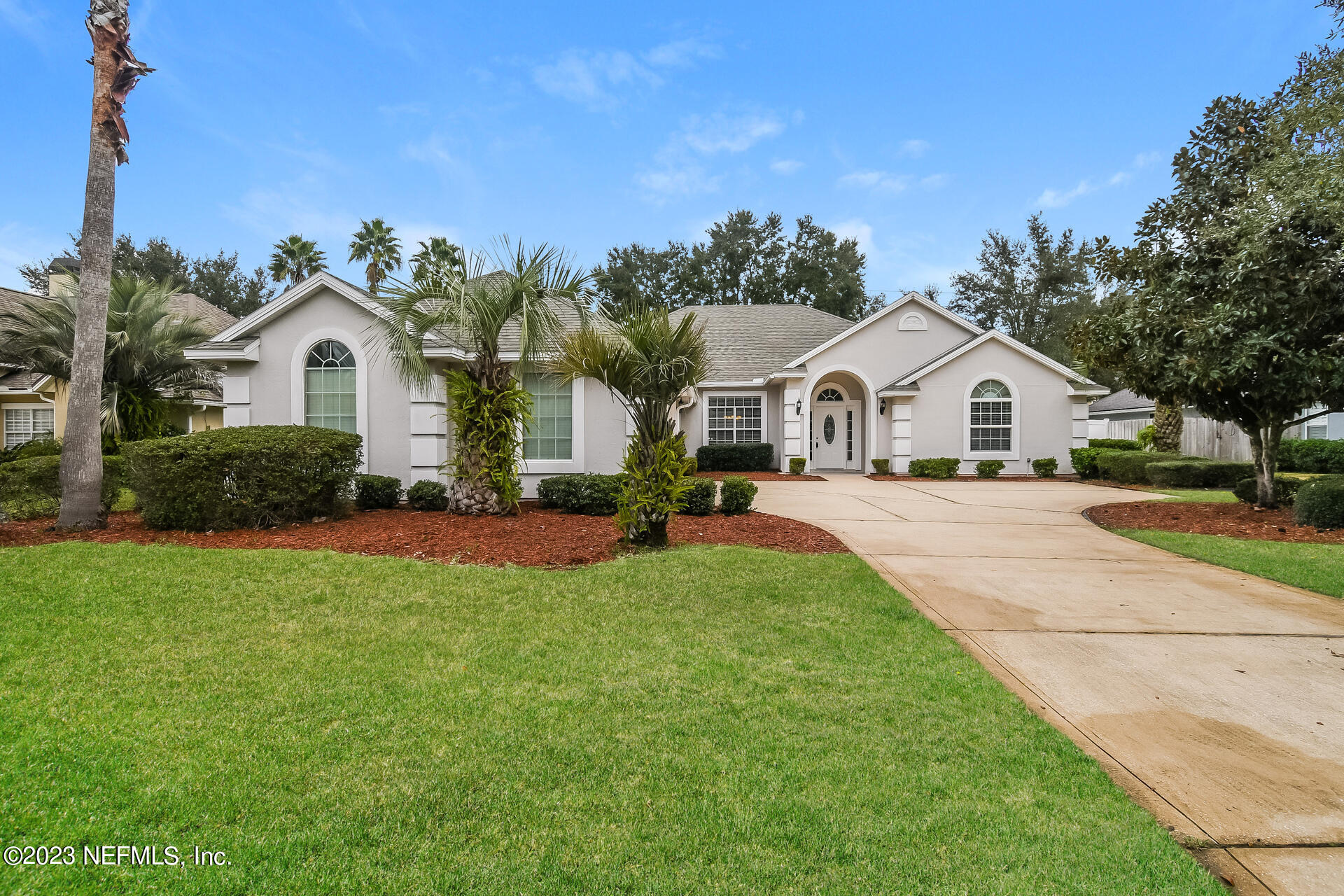 a front view of a house with a garden and trees