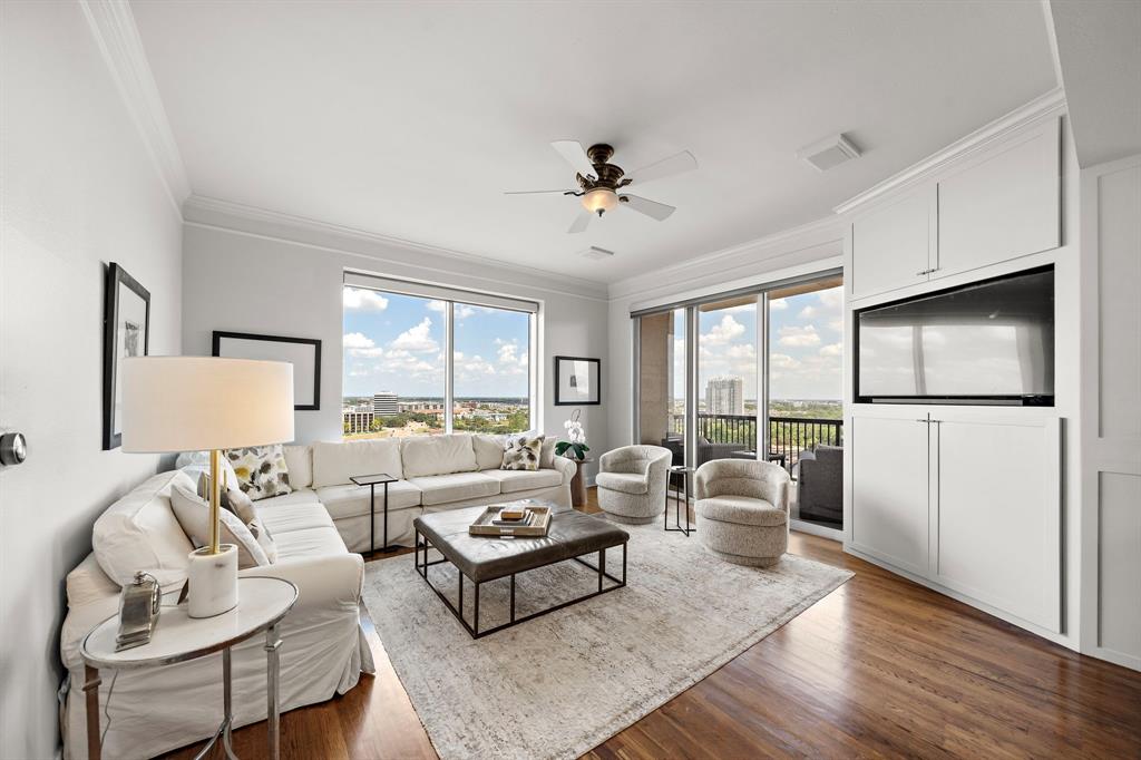 a living room with furniture a flat screen tv and a large window