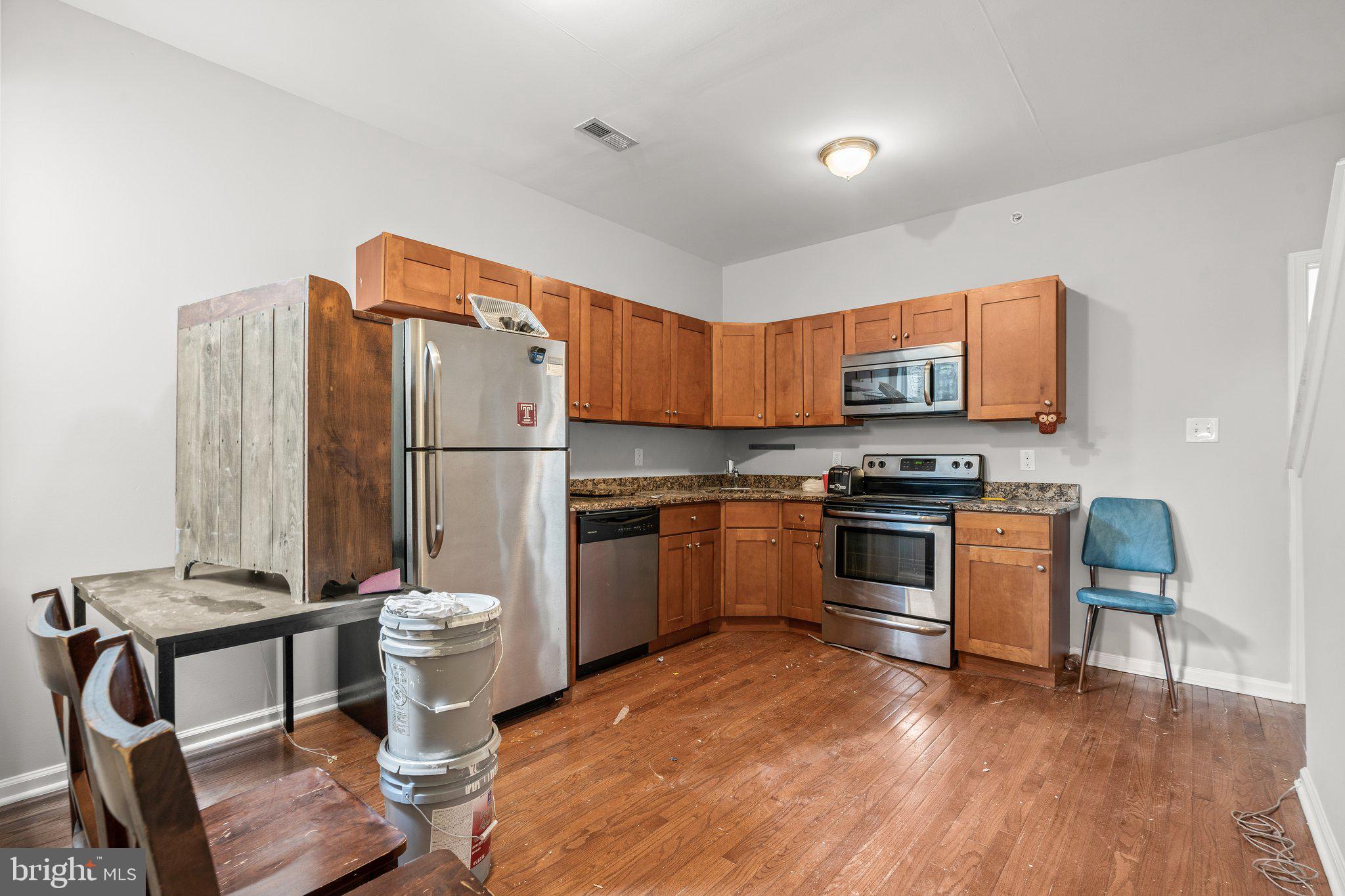 a kitchen with stainless steel appliances granite countertop a stove a sink and a refrigerator