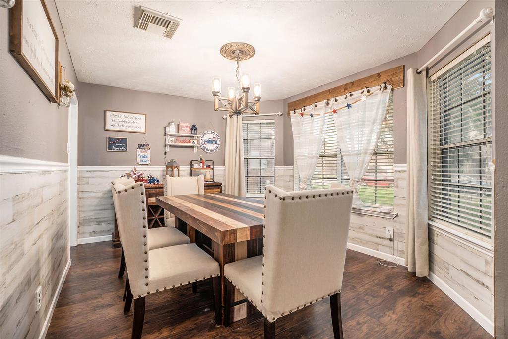 a dining room with furniture a chandelier and wooden floor