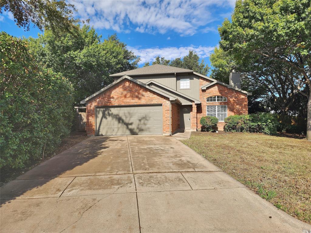 a front view of a house with a yard and trees