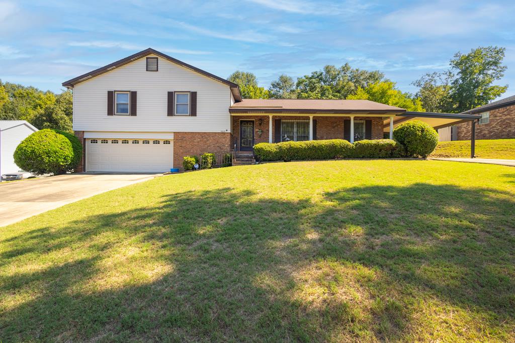 a front view of house with yard and trees around