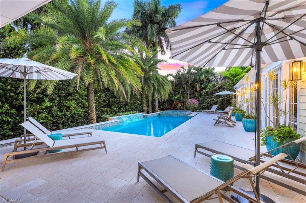 a view of a patio with a table and chairs under an umbrella