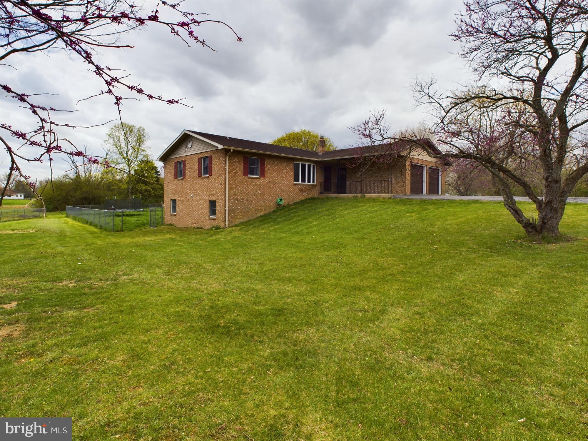 a house that is sitting in the grass with large trees