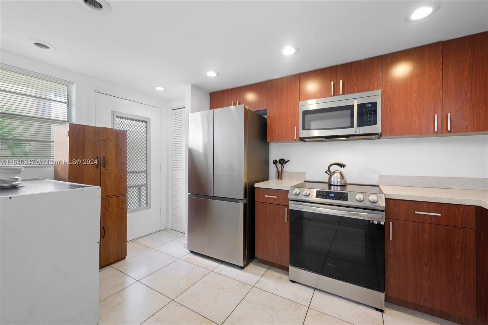 a kitchen with stainless steel appliances granite countertop a refrigerator and a stove top oven