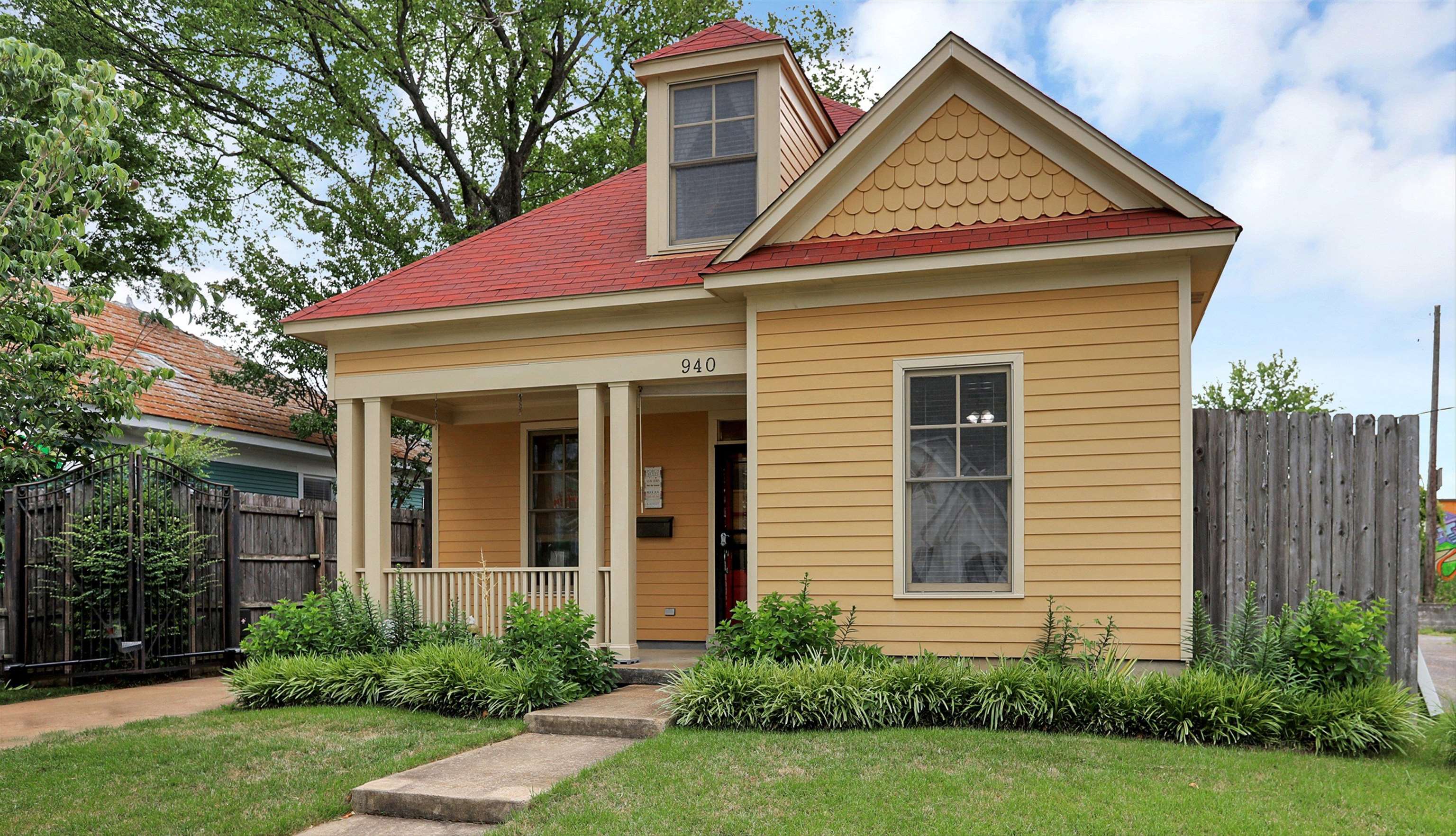 a view of a house with brick walls and a yard with plants