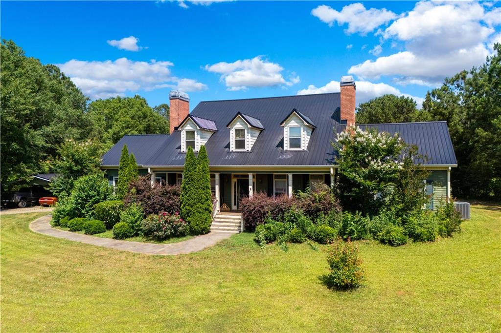 a front view of house with yard and trees around