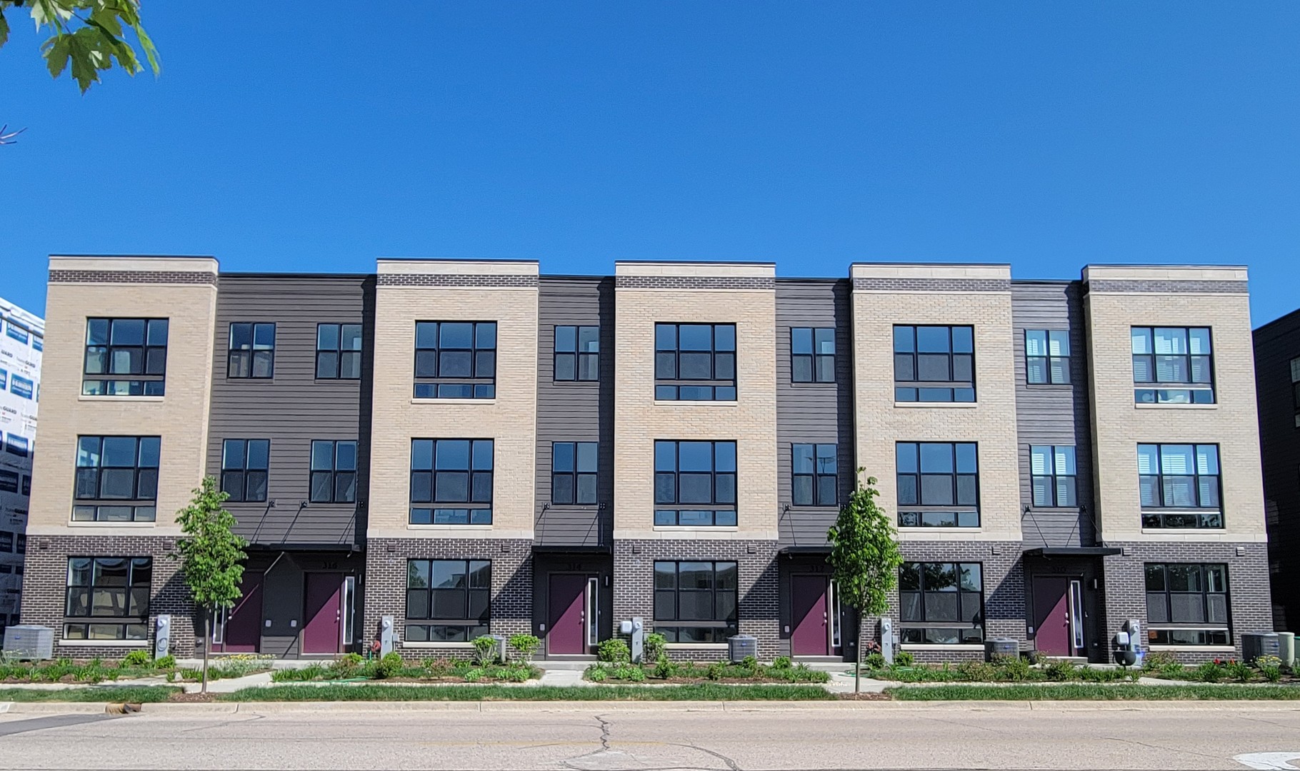 a front view of multi story residential apartment building with yard