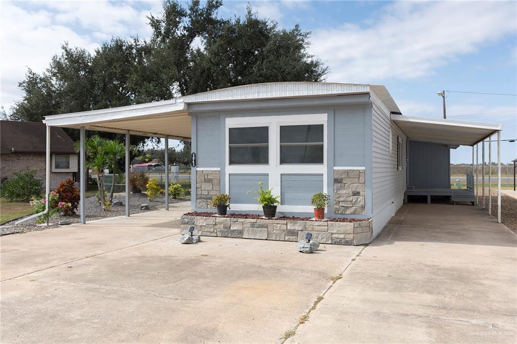 Mature trees line the property, providing shade and enhancing the home's curb appeal.  Look at the stone facade that modernizes this home and adds such an updated look!  Back covered deck and large carport plus a great yard!