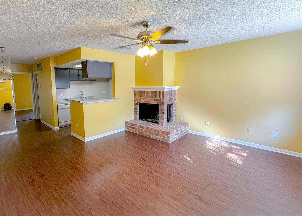 a living room with wooden floors and a fireplace