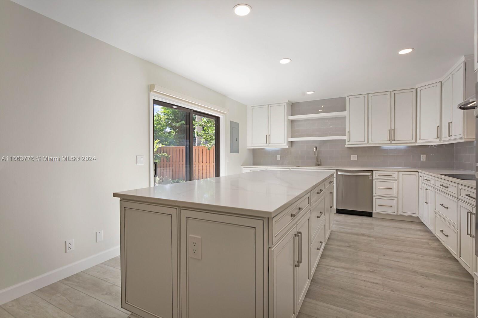 a kitchen with a sink stove cabinets and wooden floor