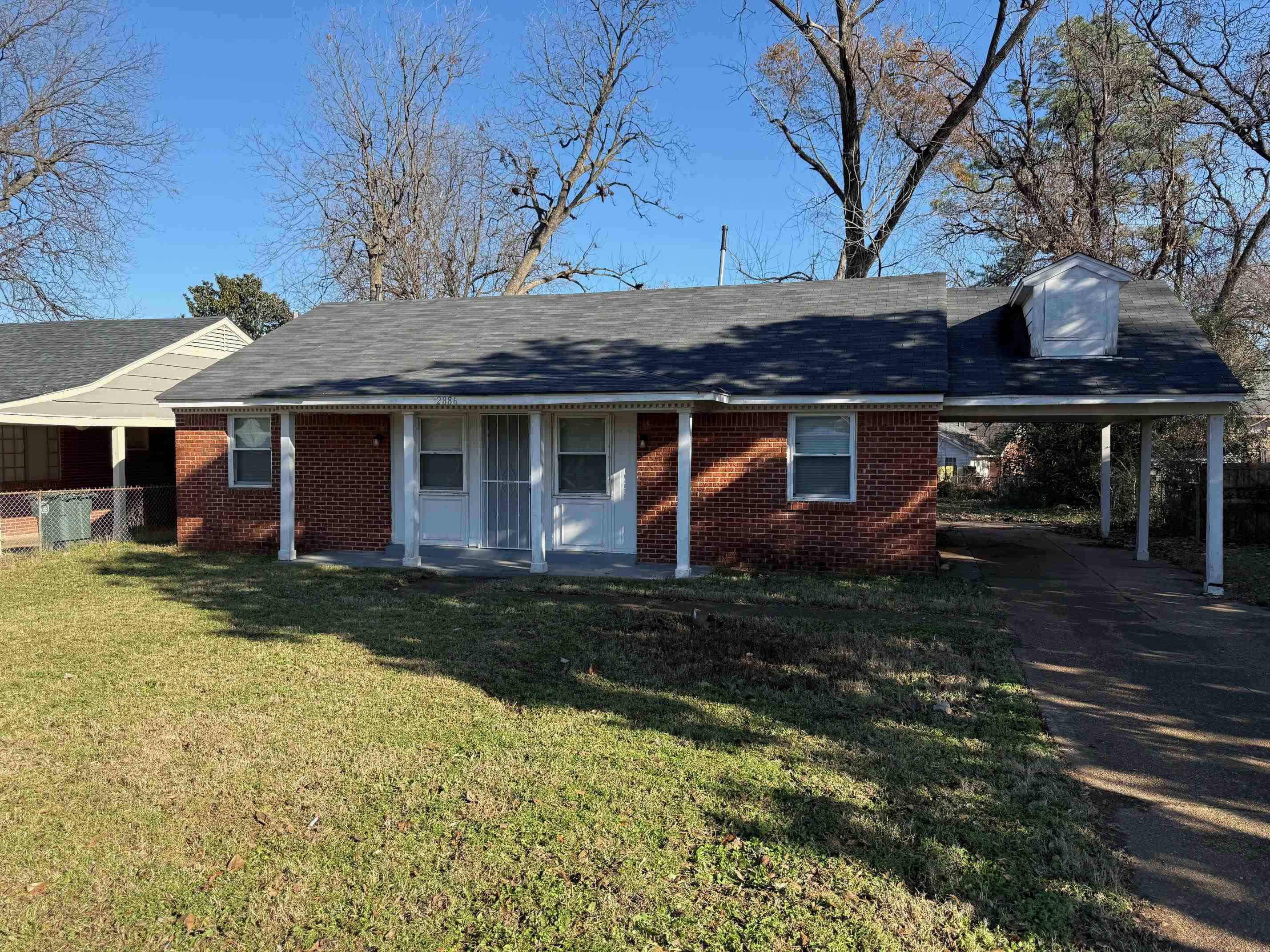 View of front facade with a carport and a front yard