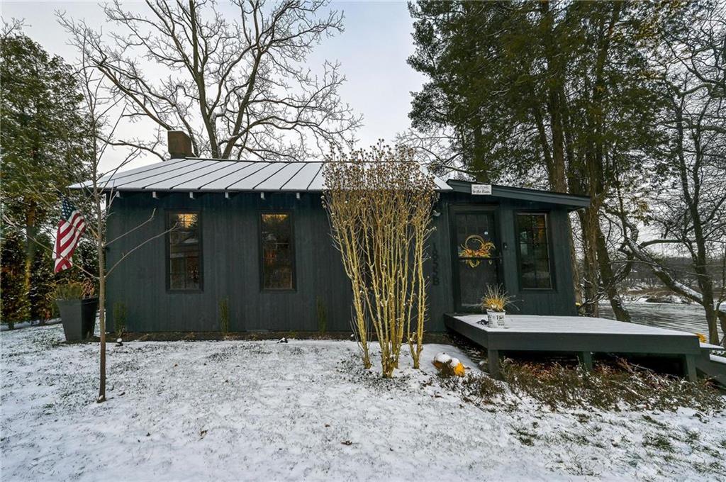 a view of a small house with a yard and large tree