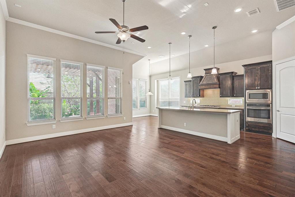 a large kitchen with kitchen island a large counter top appliances and cabinets