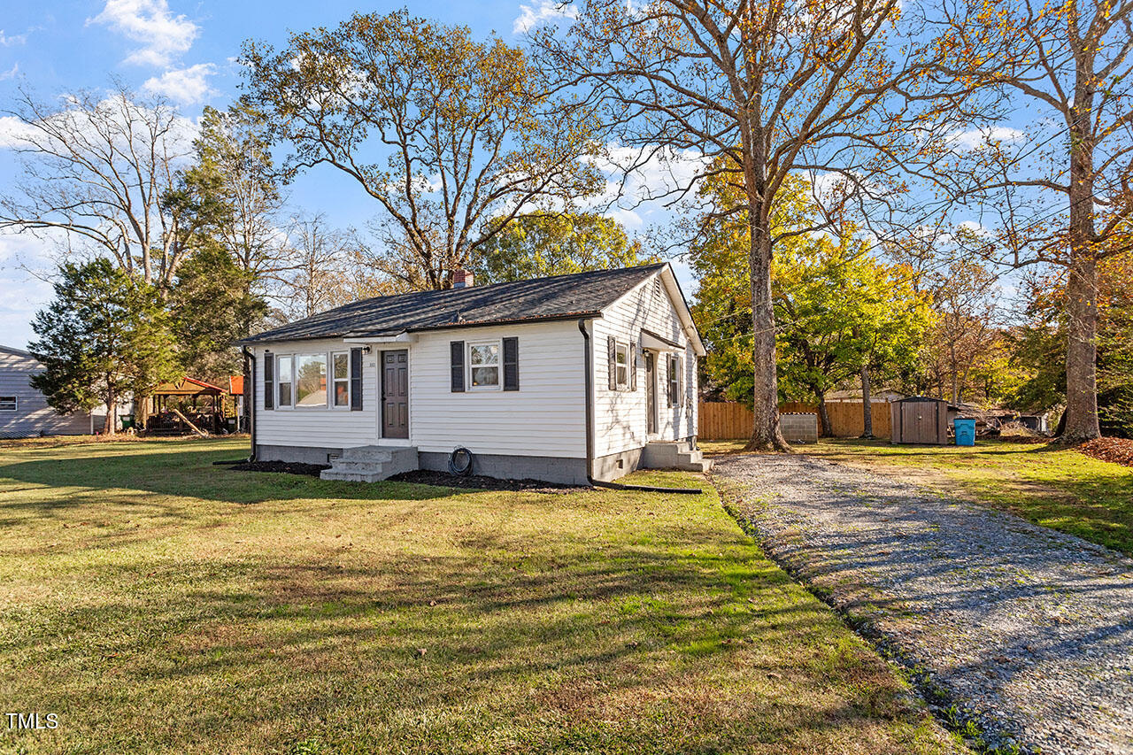 a view of a house with a yard and tree s