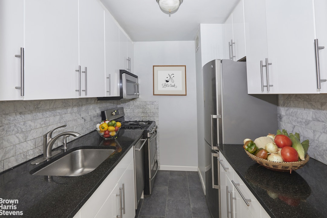 a kitchen with stainless steel appliances granite countertop a sink a refrigerator and a stove