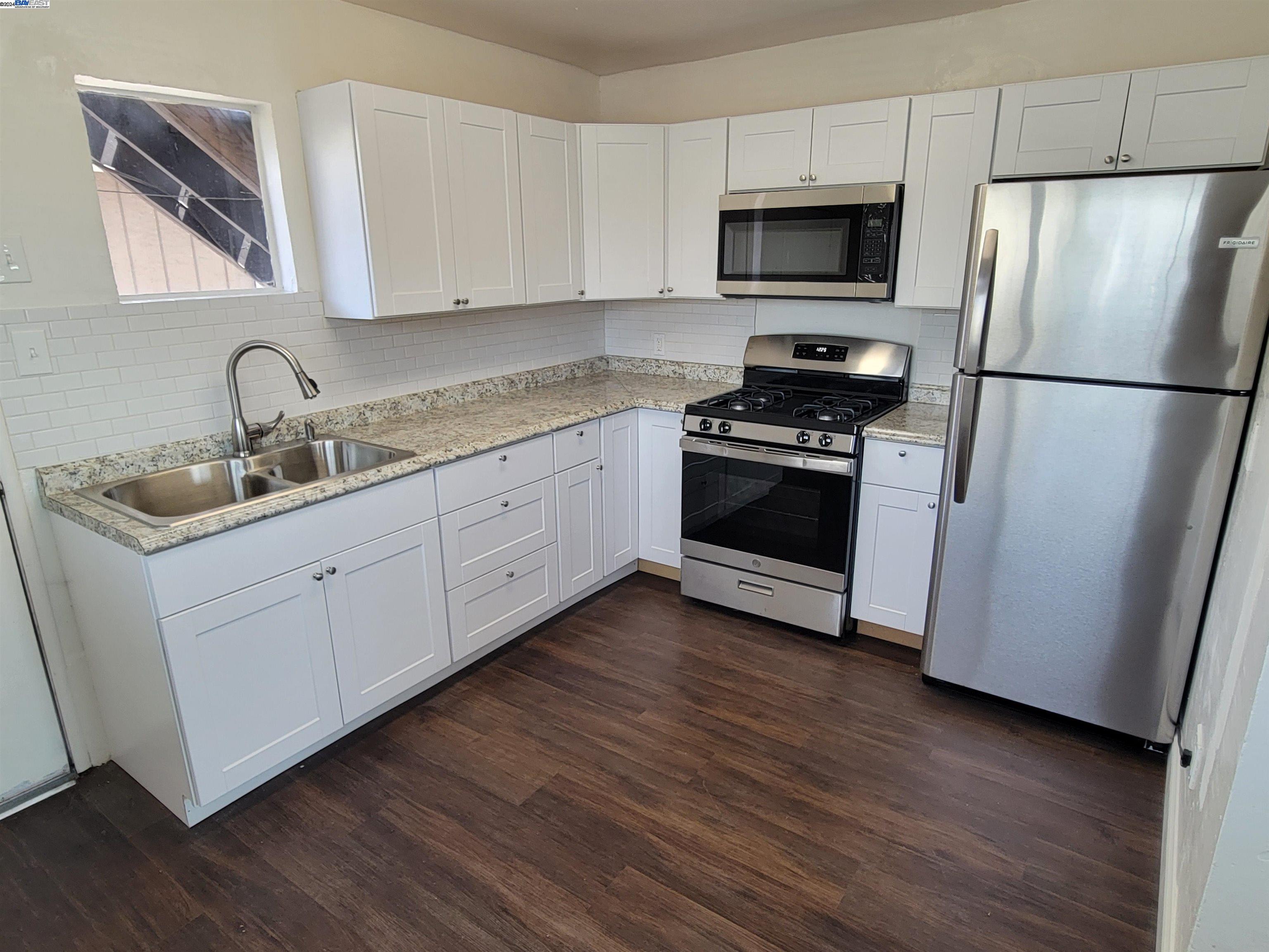 a kitchen with sink a microwave and refrigerator