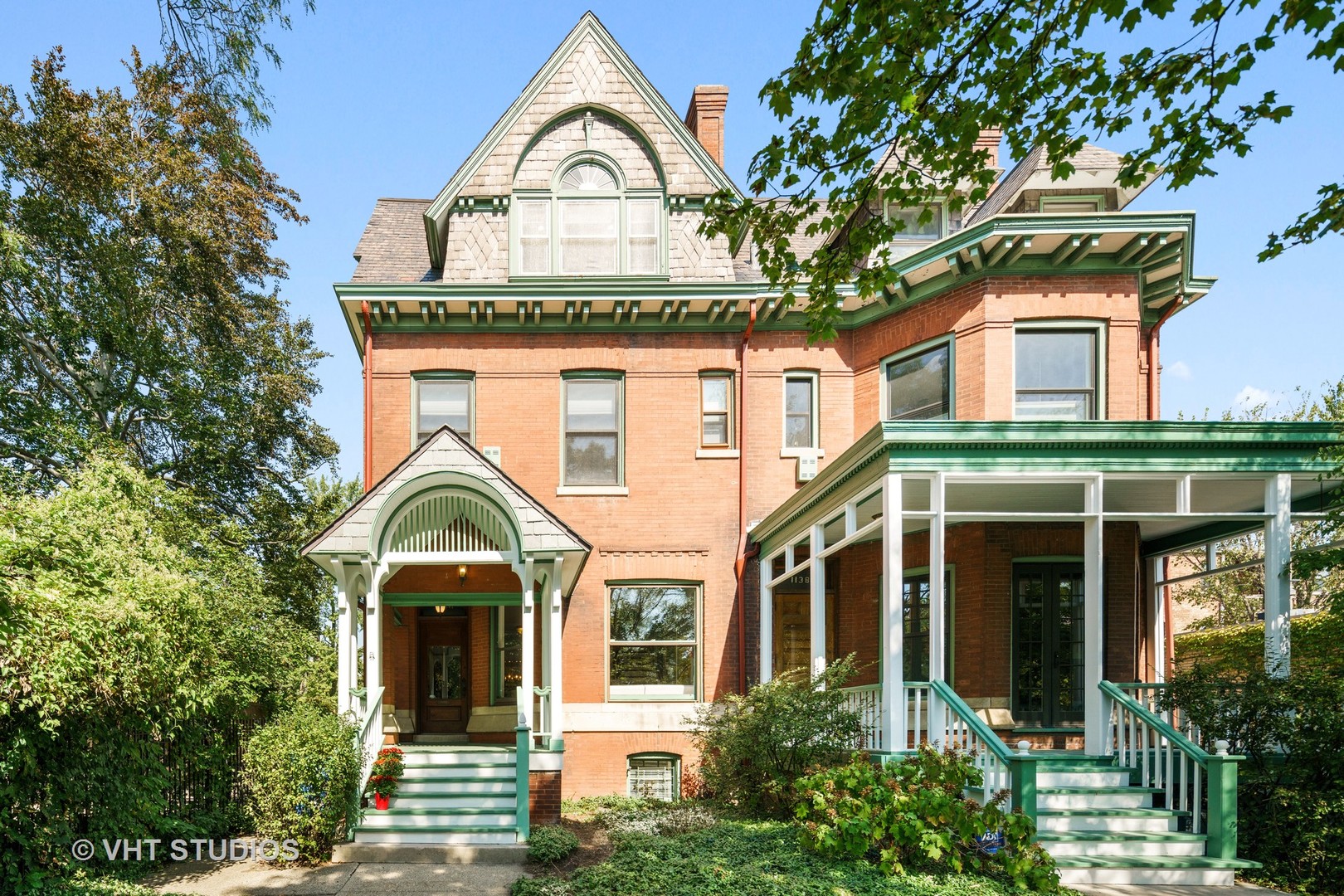 a view of a white house with large windows and a large tree