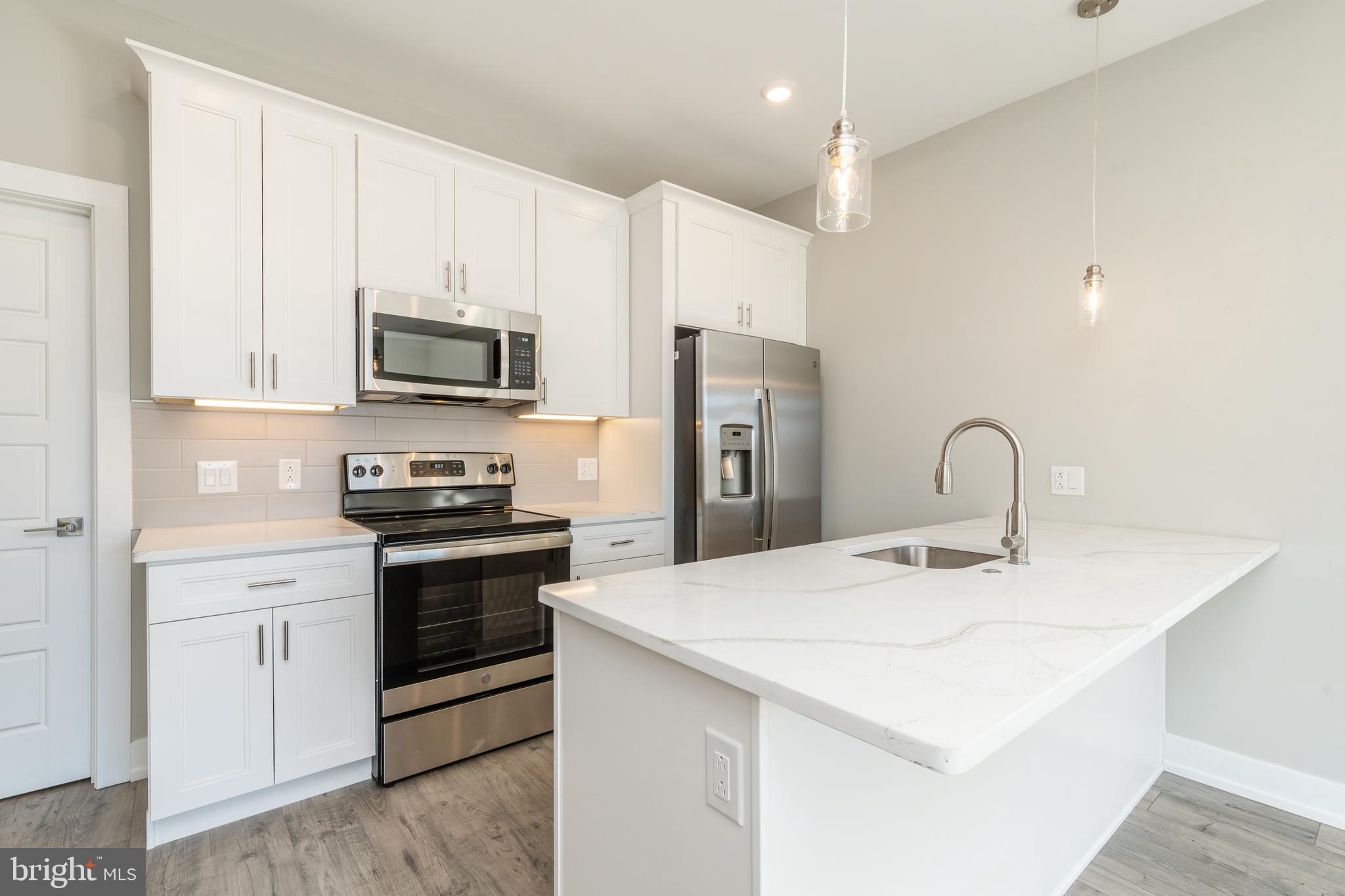 a kitchen with stainless steel appliances a stove microwave and sink