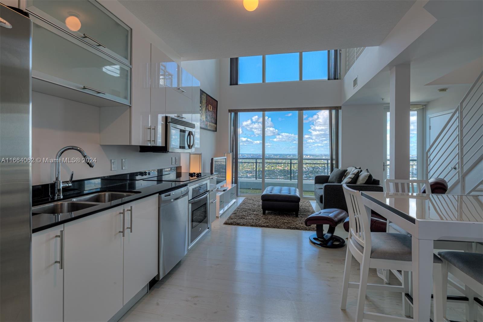 a large kitchen with a large window and stainless steel appliances