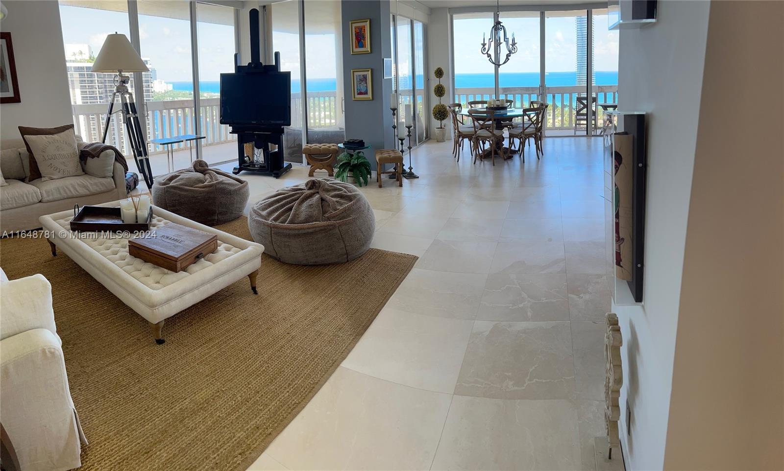 a living room with furniture and floor to ceiling windows