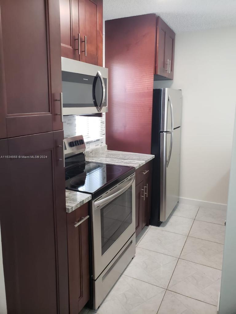 a kitchen with a stove top oven and refrigerator