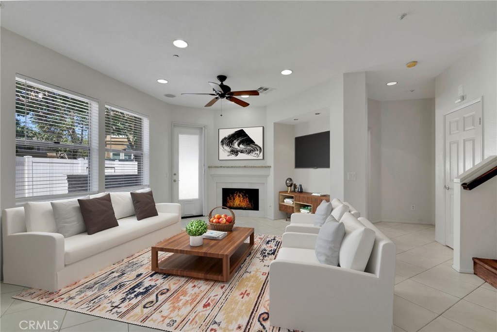 a living room with furniture a fireplace and a flat screen tv