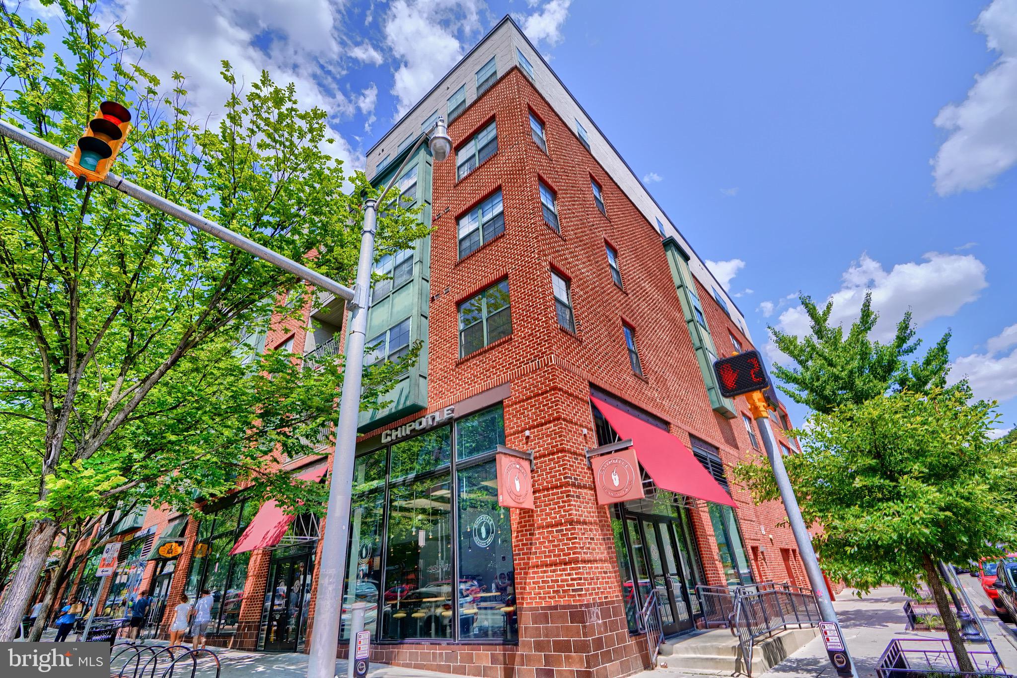 a front view of a multi story residential apartment building with yard