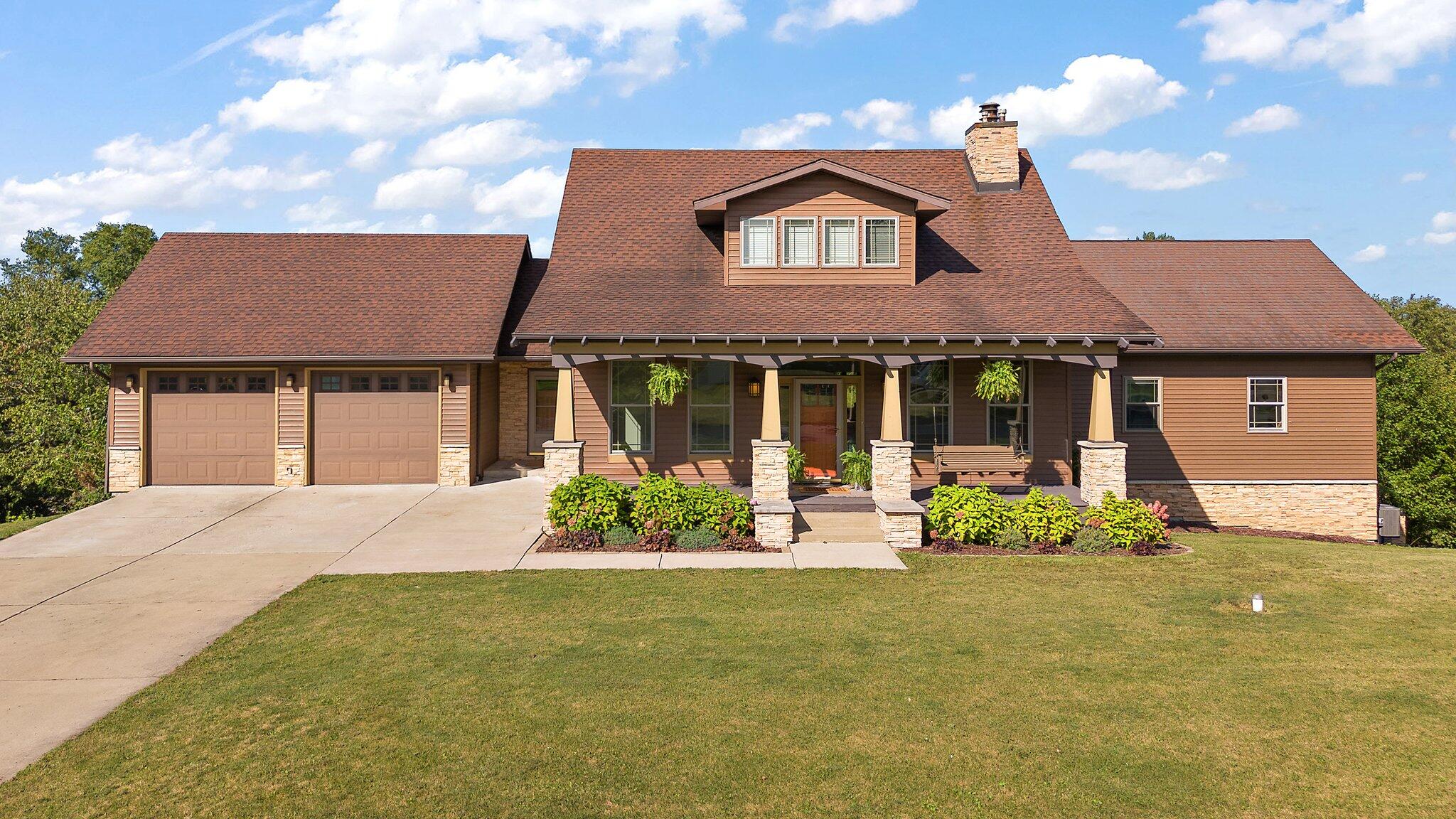 a front view of a house with a garden and plants