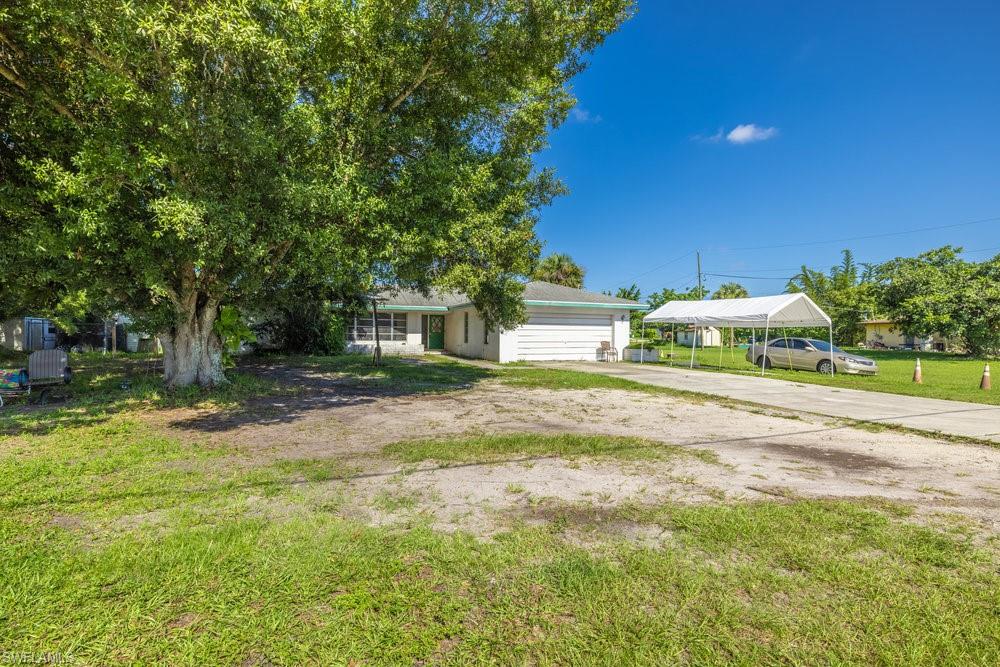 a view of a house with backyard and a tree