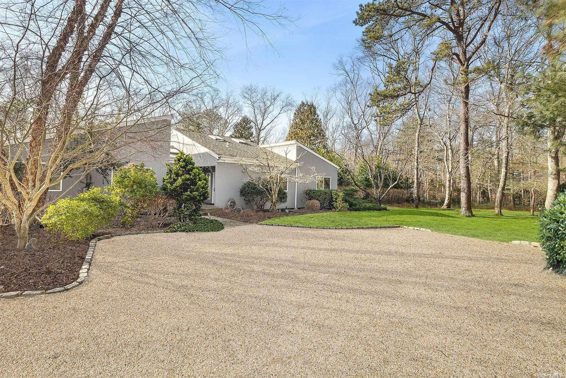 a view of a house with a big yard and large trees