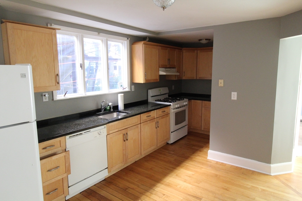 a kitchen with stainless steel appliances a sink a stove a refrigerator and cabinets