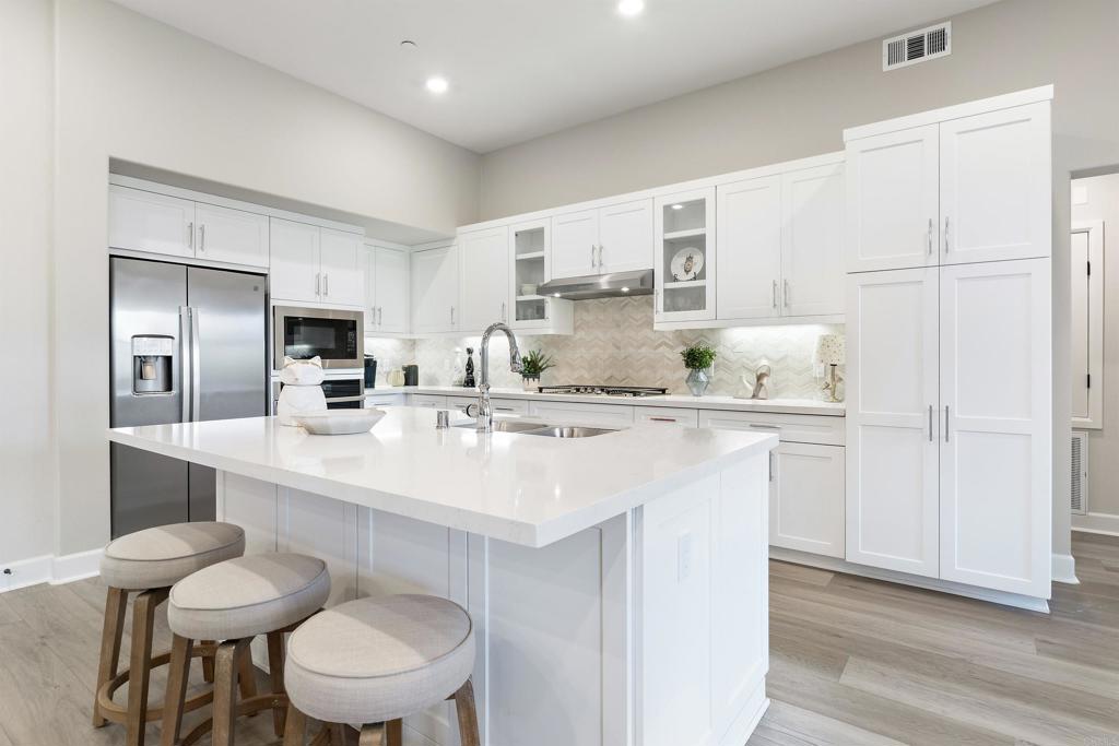 a kitchen with stainless steel appliances a sink and a refrigerator