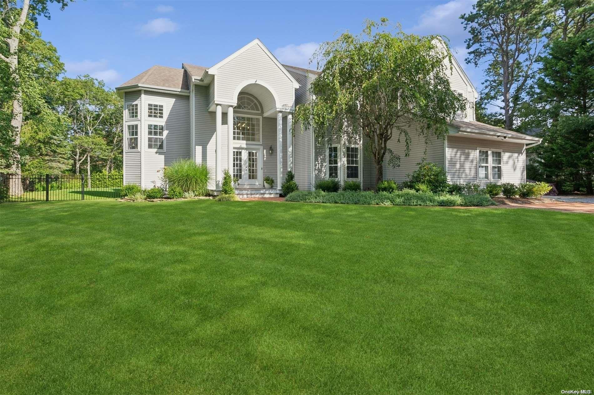 a view of a house with a big yard and large trees