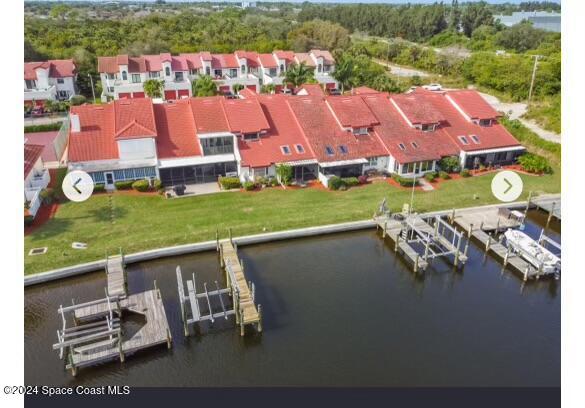 an aerial view of a house with a garden and lake view