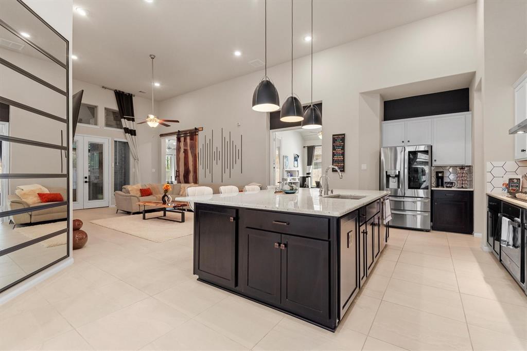 a kitchen with stainless steel appliances kitchen island granite countertop a sink and a refrigerator