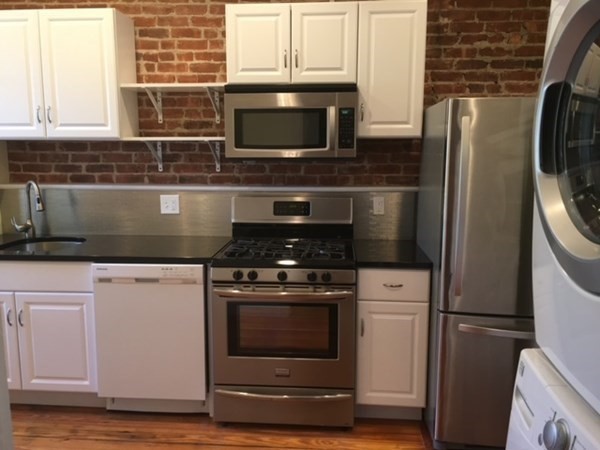 a kitchen with stainless steel appliances a stove a microwave and a refrigerator