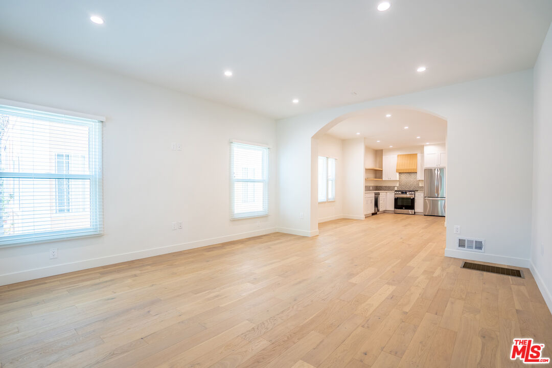 a view of empty room with a kitchen and window