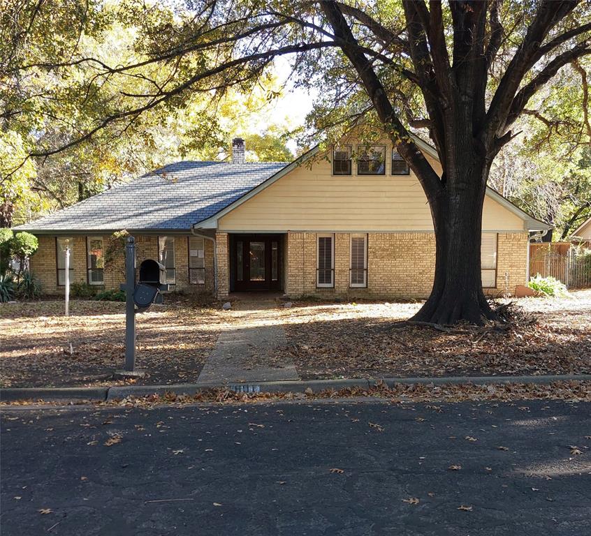 a view of a house with a tree in front of it